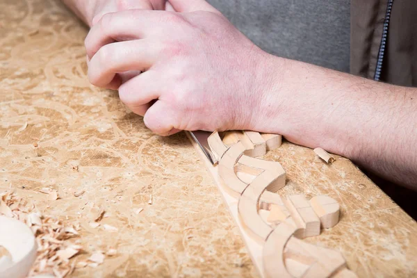Woodcarver crea un ornamento per mobili. Mani, scalpelli, utensili, ornamenti in legno intagliato . — Foto Stock