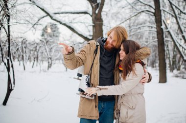 Kış ve tarih. Adama aşık genç çift ve kış karla kaplı ağaçlar Park çerçevede kadında kucaklama vardır. Uzun saç ve sakal bir adamla paten tutar ve kız seviyor