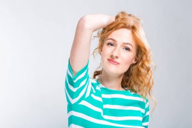 Mavi gri bir arka plan üzerinde stüdyoda şeritler ile yakın çekim portre bir yazlık elbise kırmızı kıvırcık saçlı genç, güzel bir kadının. Yaz tatil, turizm ve yaz giysileri Tema