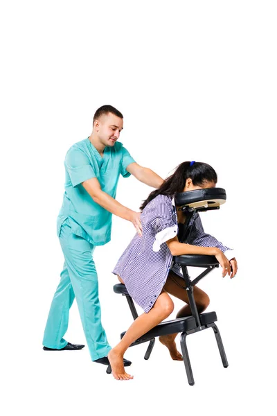 Tema masaje y oficina. Terapeuta masculino con traje azul haciendo masaje de espalda y cuello para trabajadora joven, mujer de negocios con camisa en silla de masaje shiatsu — Foto de Stock