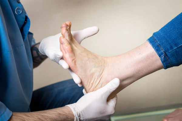 The hands of a young man doctor orthopedist conducts diagnostics, foot foot test of a woman, for the manufacture of individual, orthopedic insoles — Stock Photo, Image