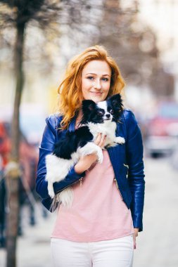 Konu adam ve bir köpek. Genç Kızıl saçlı beyaz bir kadın yüzündeki çiller ile siyah beyaz tüylü chihuahua cins köpek tutar. Mavi deri ceket giymiş kız bahar aylarında işlek cadde üzerinde duruyor