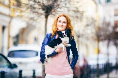 Konu adam ve bir köpek. Genç Kızıl saçlı beyaz bir kadın yüzündeki çiller ile siyah beyaz tüylü chihuahua cins köpek tutar. Mavi deri ceket giymiş kız bahar aylarında işlek cadde üzerinde duruyor