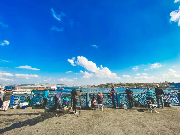 27 de octubre de 2019 Estambul. Pavo. Pescador pescando en el puente de Galata en Estambul Turquía. La gente camina por el puente de Galata. Vacaciones en Estambul. Puente de Galata lugar tradicional favorito para la pesca — Foto de Stock