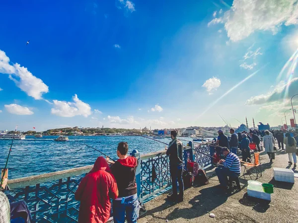 27 października 2019 Stambuł. Turcja. Rybak łowiący na moście Galata w Stambule Turcja. Ludzie chodzą po moście Galata. Wakacje w Istambule. Galata Bridge ulubione tradycyjne miejsce do łowienia ryb — Zdjęcie stockowe
