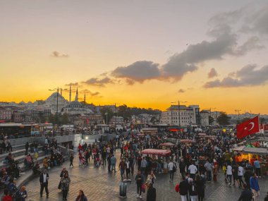 27 Ekim 2019. Eminonu Meydanı gün batımında, İstanbul 'da, Türkiye' de. Türkiye 'de Galata Köprüsü yakınlarındaki bir meydanda, İstanbul' da alışveriş ve tarihi varış noktasında insanlar dinleniyor ve sosyalleşiyor