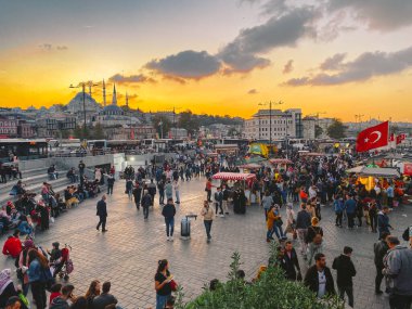 27 Ekim 2019. Eminonu Meydanı gün batımında, İstanbul 'da, Türkiye' de. Türkiye 'de Galata Köprüsü yakınlarındaki bir meydanda, İstanbul' da alışveriş ve tarihi varış noktasında insanlar dinleniyor ve sosyalleşiyor