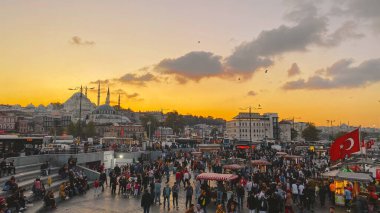 27 Ekim 2019. Eminonu Meydanı gün batımında, İstanbul 'da, Türkiye' de. Türkiye 'de Galata Köprüsü yakınlarındaki bir meydanda, İstanbul' da alışveriş ve tarihi varış noktasında insanlar dinleniyor ve sosyalleşiyor