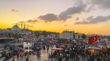 27 Ekim 2019. Eminonu Meydanı gün batımında, İstanbul 'da, Türkiye' de. Türkiye 'de Galata Köprüsü yakınlarındaki bir meydanda, İstanbul' da alışveriş ve tarihi varış noktasında insanlar dinleniyor ve sosyalleşiyor