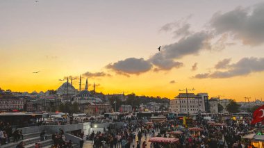 27 Ekim 2019. Eminonu Meydanı gün batımında, İstanbul 'da, Türkiye' de. Türkiye 'de Galata Köprüsü yakınlarındaki bir meydanda, İstanbul' da alışveriş ve tarihi varış noktasında insanlar dinleniyor ve sosyalleşiyor