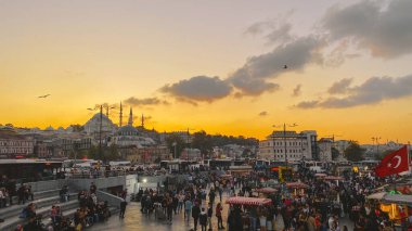 27 Ekim 2019. Eminonu Meydanı gün batımında, İstanbul 'da, Türkiye' de. Türkiye 'de Galata Köprüsü yakınlarındaki bir meydanda, İstanbul' da alışveriş ve tarihi varış noktasında insanlar dinleniyor ve sosyalleşiyor
