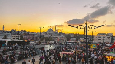 27 Ekim 2019. Eminonu Meydanı gün batımında, İstanbul 'da, Türkiye' de. Türkiye 'de Galata Köprüsü yakınlarındaki bir meydanda, İstanbul' da alışveriş ve tarihi varış noktasında insanlar dinleniyor ve sosyalleşiyor