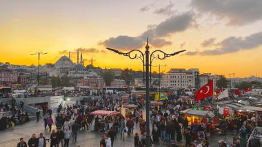 27 Ekim 2019. Eminonu Meydanı gün batımında, İstanbul 'da, Türkiye' de. Türkiye 'de Galata Köprüsü yakınlarındaki bir meydanda, İstanbul' da alışveriş ve tarihi varış noktasında insanlar dinleniyor ve sosyalleşiyor