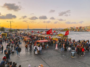 27 Ekim 2019. Eminonu Meydanı gün batımında, İstanbul 'da, Türkiye' de. Türkiye 'de Galata Köprüsü yakınlarındaki bir meydanda, İstanbul' da alışveriş ve tarihi varış noktasında insanlar dinleniyor ve sosyalleşiyor