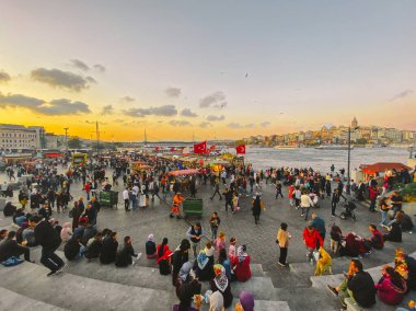 27 Ekim 2019. Eminonu Meydanı gün batımında, İstanbul 'da, Türkiye' de. Türkiye 'de Galata Köprüsü yakınlarındaki bir meydanda, İstanbul' da alışveriş ve tarihi varış noktasında insanlar dinleniyor ve sosyalleşiyor