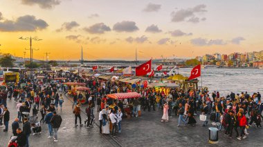 27 Ekim 2019. Eminonu Meydanı gün batımında, İstanbul 'da, Türkiye' de. Türkiye 'de Galata Köprüsü yakınlarındaki bir meydanda, İstanbul' da alışveriş ve tarihi varış noktasında insanlar dinleniyor ve sosyalleşiyor