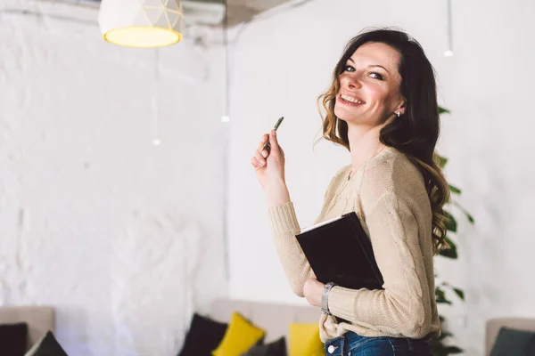 Empresária inteligente em pé no escritório moderno e segurando tablet de papel com caneta. Conceito de trabalho de empreendedor bem sucedido. Mulher de negócios segurando diário e caneta. Empreendedorismo PME — Fotografia de Stock