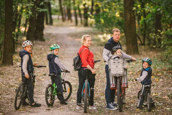 Rodziców i dzieci jeżdżących po leśnym szlaku. rodzina w ciepłych ubraniach rowerowych jesienny park. Rodzinny rower górski w lesie. aktywny sport rekreacji na świeżym powietrzu. Portret Rodzina jazda na rowerze przez jesień Woodland — Zdjęcie stockowe