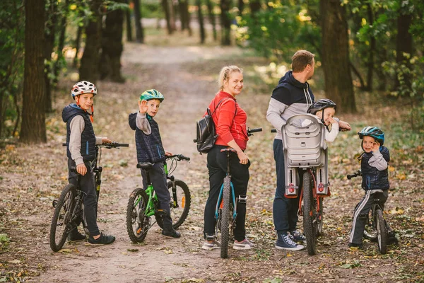 Rodziców i dzieci jeżdżących po leśnym szlaku. rodzina w ciepłych ubraniach rowerowych jesienny park. Rodzinny rower górski w lesie. aktywny sport rekreacji na świeżym powietrzu. Portret Rodzina jazda na rowerze przez jesień Woodland — Zdjęcie stockowe