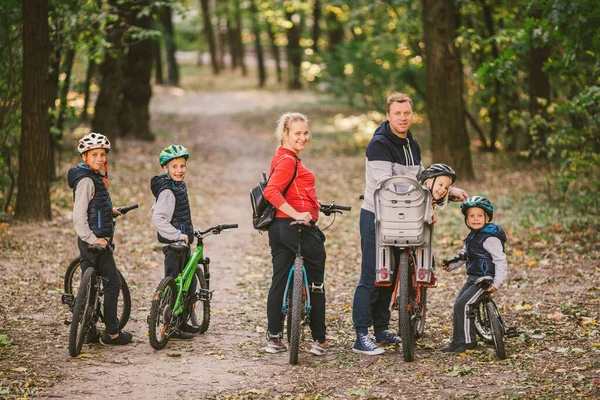 Rodziców i dzieci jeżdżących po leśnym szlaku. rodzina w ciepłych ubraniach rowerowych jesienny park. Rodzinny rower górski w lesie. aktywny sport rekreacji na świeżym powietrzu. Portret Rodzina jazda na rowerze przez jesień Woodland — Zdjęcie stockowe