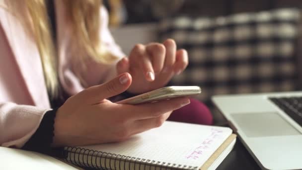 Kobieta siedzi w kawiarni drewniany stół, pije kawę i za pomocą smartfona. Kobieta używająca telefonu w kawiarni. Student uczy się online. Dziewczyna sprawdza maile. Woman Cafe, użyj telefonu komórkowego, Notatnik roboczy — Wideo stockowe