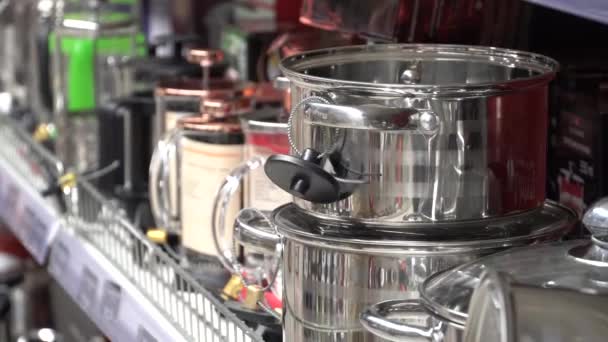 Le sujet de l'achat d'ustensiles de cuisine dans un supermarché. jeune homme caucasien choisit évalue les marchandises va au département, inspecte l'article et ajoute au panier — Video