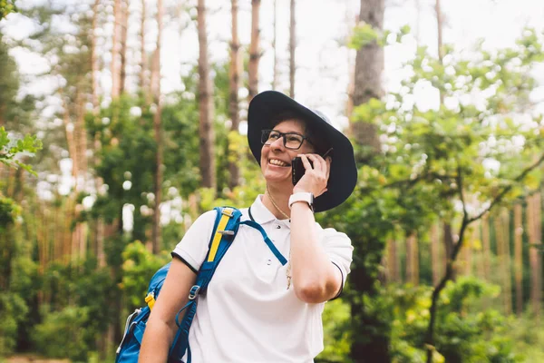 Mulher Caminhante a falar no telemóvel. camping, viagens, estilo de vida, recreação ou bom sinal de smartphone no conceito de floresta . — Fotografia de Stock