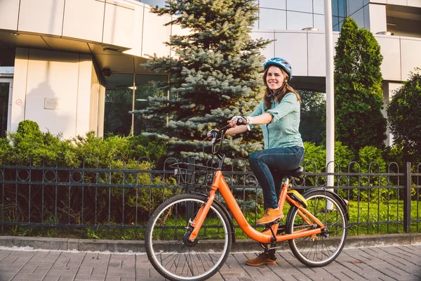 Bisikletli çekici, arkadaş canlısı genç bayan. Sokakta bisikletli genç bir kadının portresi. Ekolojik bisiklet taşımacılığı. Öğrenci kız okula kiralık bir bisikletle çalışmaya geldi. — Stok fotoğraf
