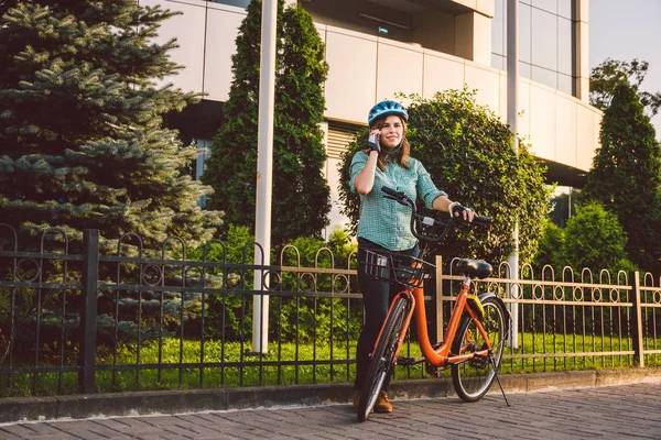 Portret wesołej dziewczyny trzymającej telefon komórkowy. Szczęśliwy uśmiechnięty student korzystający z aplikacji udostępniania rowerów na smartfonie na świeżym powietrzu. Stylowa dziewczyna hipster City z rowerem za pomocą aplikacji smartfon na ulicy — Zdjęcie stockowe