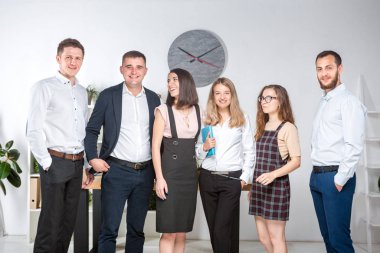 Gülümseyen çalışanlar kameraya bakıp ofiste takım fotoğrafı çekiyorlar. İş Adamları Takımı. Mutlu işçilerle başarılı bir birliktelik. İletişim Kurumsal Takım Çalışması Konseptiyle Tanışan İnsanlar