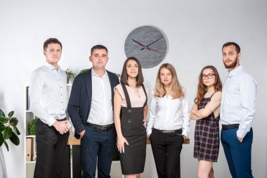 Gülümseyen çalışanlar kameraya bakıp ofiste takım fotoğrafı çekiyorlar. İş Adamları Takımı. Mutlu işçilerle başarılı bir birliktelik. İletişim Kurumsal Takım Çalışması Konseptiyle Tanışan İnsanlar