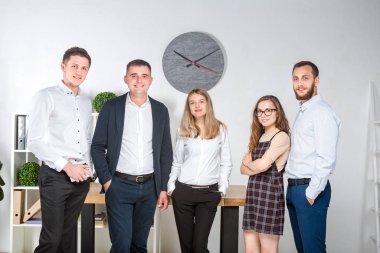 Gülümseyen çalışanlar kameraya bakıp ofiste takım fotoğrafı çekiyorlar. İş Adamları Takımı. Mutlu işçilerle başarılı bir birliktelik. İletişim Kurumsal Takım Çalışması Konseptiyle Tanışan İnsanlar