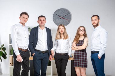 Gülümseyen çalışanlar kameraya bakıp ofiste takım fotoğrafı çekiyorlar. İş Adamları Takımı. Mutlu işçilerle başarılı bir birliktelik. İletişim Kurumsal Takım Çalışması Konseptiyle Tanışan İnsanlar