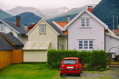 Renkli ahşap binaların kırsal manzarası. Norveç 'teki kayıkhaneler. İskandinav geleneksel kayıkhaneleri. Norveç 'in kıyı kesimindeki çok renkli garaj ahşap evleri