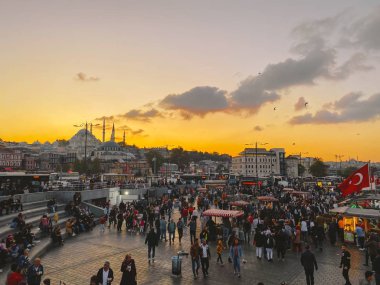 27 Ekim 2019. Eminonu Meydanı gün batımında, İstanbul 'da, Türkiye' de. Türkiye 'de Galata Köprüsü yakınlarındaki bir meydanda, İstanbul' da alışveriş ve tarihi varış noktasında insanlar dinleniyor ve sosyalleşiyor