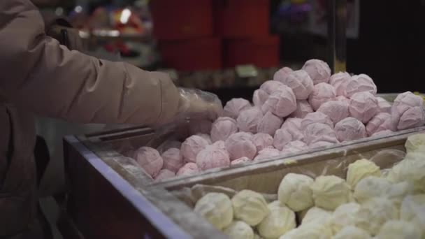 Händerna i handskarna. Köparen i butiken går upp marshmallows godis i vikt. Kvinna köper zephyr i snabbköpet av vikt. läcker söt dessert vit zephyr marshmallows i konditori — Stockvideo