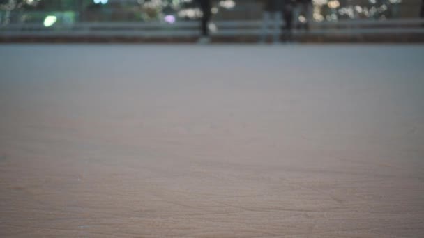 Le gambe di persone irriconoscibili cavalcano su una pista di pattinaggio su ghiaccio aperta in città la sera. Pattinaggio invernale pista di pattinaggio pubblico sulla Fiera di Natale. Persone pattinare sulla pista di pattinaggio a Kiev, Ucraina sulla zona del contratto — Video Stock