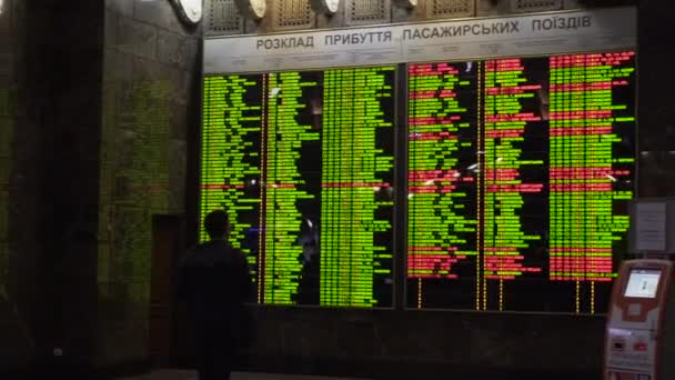 Kiev, Ukraine - 8 mars 2018 : Horaires des trains. Gare centrale de Kiev. Passagers regardant le tableau électronique des départs et des arrivées dans la gare principale de Kiev — Video