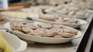 Noel panayırında sıcak yemek. Geleneksel sosisler ateşte pişerken. Markette BBQ Sosisleri. Noel pazarı yemekleri. Izgarada sosisler. Kiev 'de Yeni Yıl Fuarı
