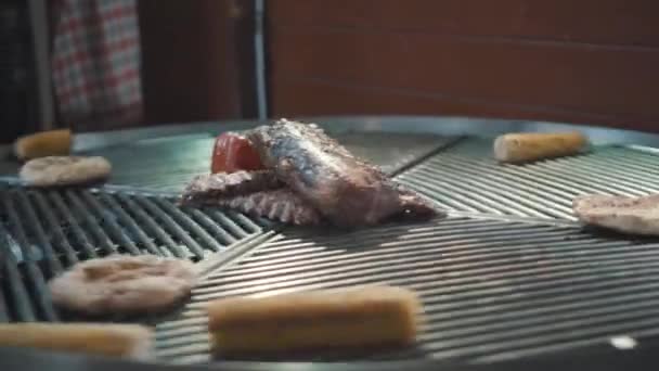 烤猪排,蔬菜烧焦. Bbq Pork Ribs在市场上的网格上。 黑暗中烤肉在炭炉上烤着. 街头食物烤肉圈旋转 — 图库视频影像