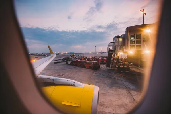 Pohled z okna okénka letadla za úsvitu na letišti v Barceloně. Téma romantiky na cestě. Cestovní ruch a cestování letadlem. Pohled z letadla na zemi — Stock fotografie