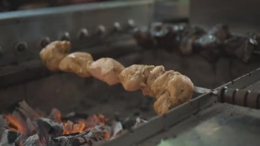 Şiş tavuk parçaları ızgarada kızarıyor ve sigara içiyor. Satılık ızgara ızgarada kızarmış tavuk. Sokak Gıda Pazarı 'nda ızgara tavuk eti satıyor. Kızarmış kümes hayvanları yakın plan.