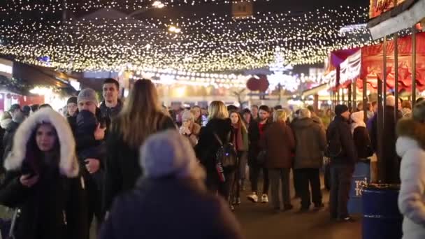 Ruota panoramica, fiera sulla piazza Kotraktova. Buonasera, Kiev. Stagione delle vacanze Kiev 21 dicembre 2019. Illuminazione festiva. Mercatino di Natale street food, mercatino di strada serale Capodanno vacanze — Video Stock