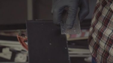 Kayak ustası. Kayak üssü plastik kazıyıcısından fazla mum çıkarıyorum. Kayak servisi ve onarım. Kış işçisi üs onarımı yapıyor. Kiralık atölye servisi. Atölye Kayak Servisi 'nde Tamirci