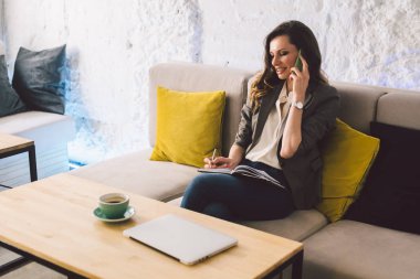 İş kadını kahve dükkanında dizüstü bilgisayarla çalışıyor. Kadın cep telefonuyla arıyor, boş zamanlarında kafede tek başına oturuyor. Serbest yazar blogcusu. Ofisin dışında çalış. Eş çalışma