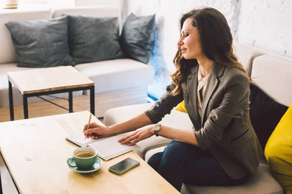 Escrever laticínios no caderno no café, conceito como memória da vida. mulher com telefone celular e caneta na mesa de madeira com xícara de café no café. Sorrindo Empresária Fazendo Notas Bloco de Notas — Fotografia de Stock