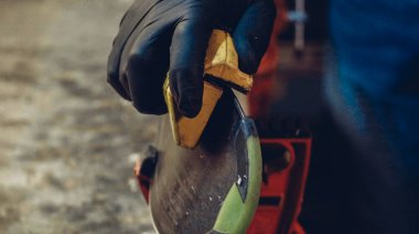 Kayak servisi atölyesinde çalışan erkek kayakları bileyip onarıyor. Kayak kenarlarını, elmas taşla tutturulmuş kenar ayarlama aleti ile keskinleştiriyorum. Kayak kaldırımının tema onarımı