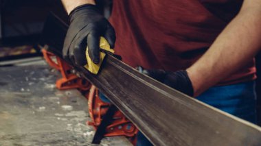 Kayak servisi atölyesinde çalışan erkek kayakları bileyip onarıyor. Kayak kenarlarını, elmas taşla tutturulmuş kenar ayarlama aleti ile keskinleştiriyorum. Kayak kaldırımının tema onarımı