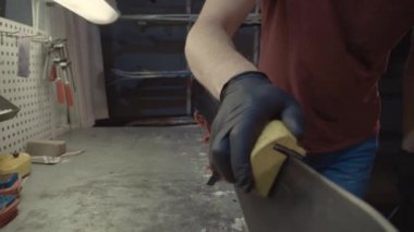 Kayak servisi atölyesinde çalışan erkek kayakları bileyip onarıyor. Kayak kenarlarını, elmas taşla tutturulmuş kenar ayarlama aleti ile keskinleştiriyorum. Kayak kaldırımının tema onarımı