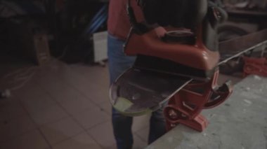 Kayak tabanına demirle sıcak mum sürüyorum. Kayak tabanına kayak cilası sürüyorum. Kayak zemini ayarlaması. Kayak demiri ve balmumu çubukları. Kayak servisi ve onarım. Atölye kayak servisinde tamirci. Atölyede Kayak Yapan Adam